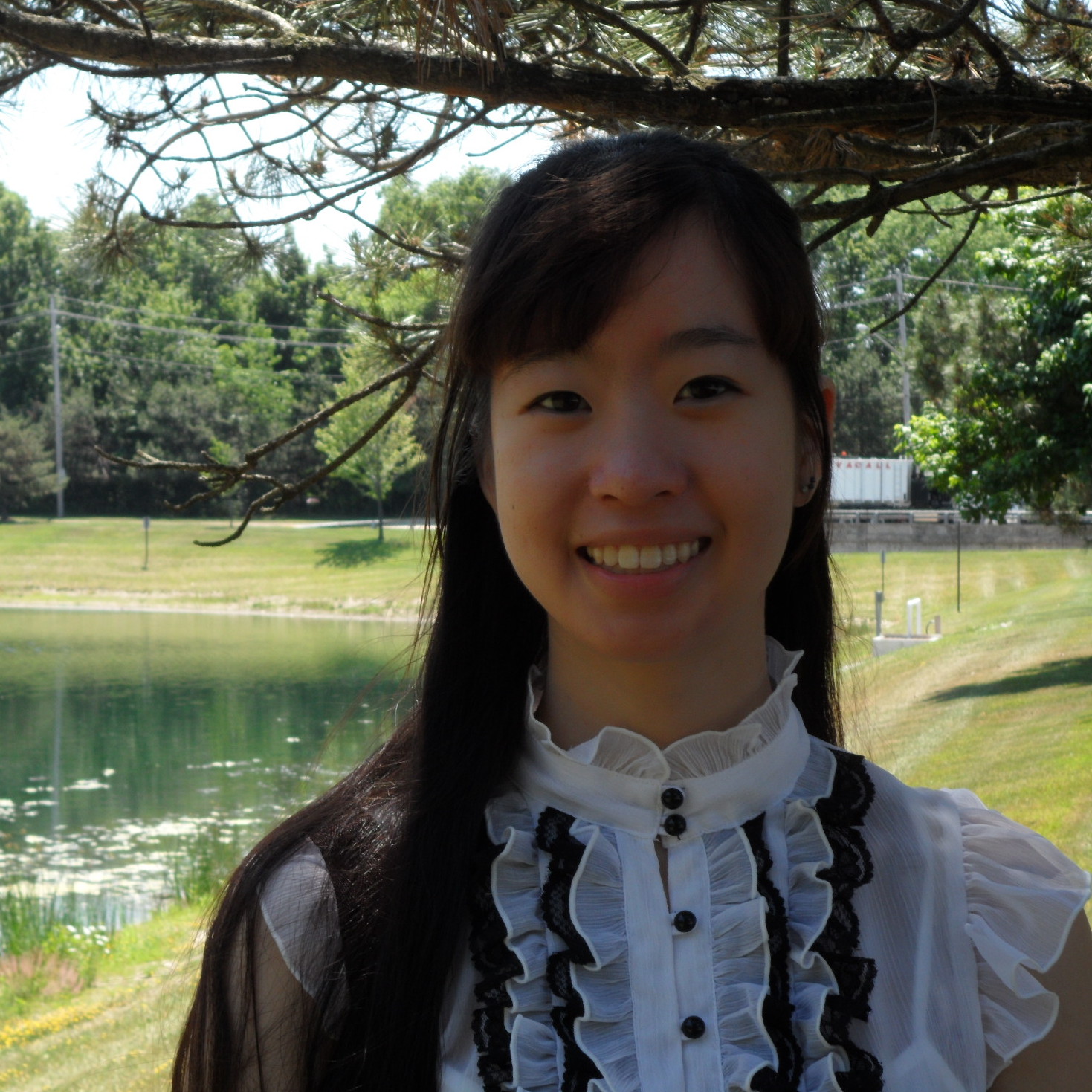 Photograph of DWRL staff member Lily Zhu, standing by a lake