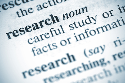 A close-up of a dictionary definition of research.