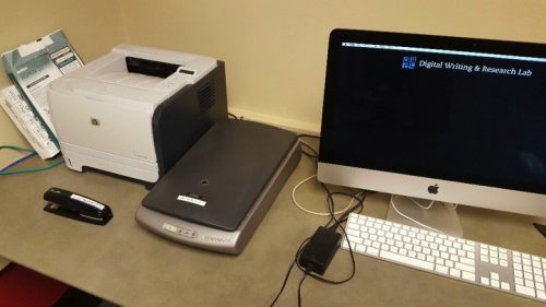 A photo of a HP printer (on the left), an Epson scanner (middle), and a Mac computer monitor and keyboard. These three items are all on a computer desk.