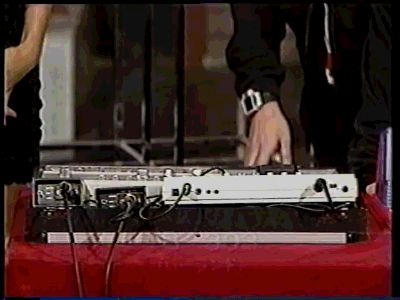Short GIF of a man displaying a tb-303, touch bass line synthesizer.