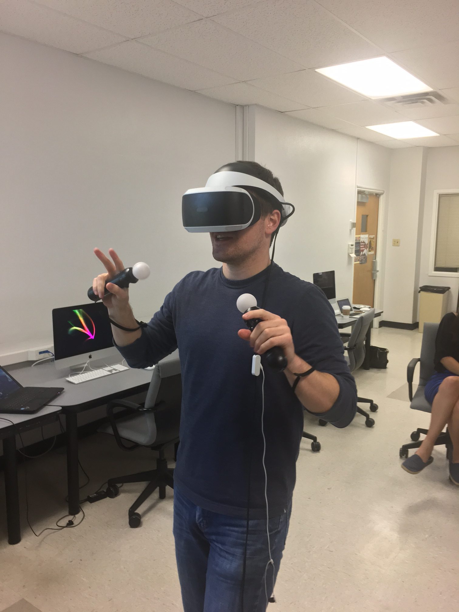 DWRL staffer Mac Scott playing the playstation with the virtual reality helmet on, and remote sensors in his hands. 