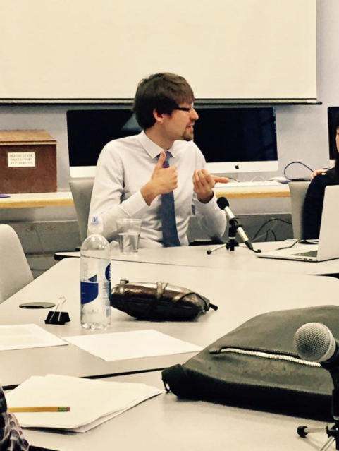 Picture of Dr. Jagoda, who has brown hair and glasses, and is sitting at a roundtable. 