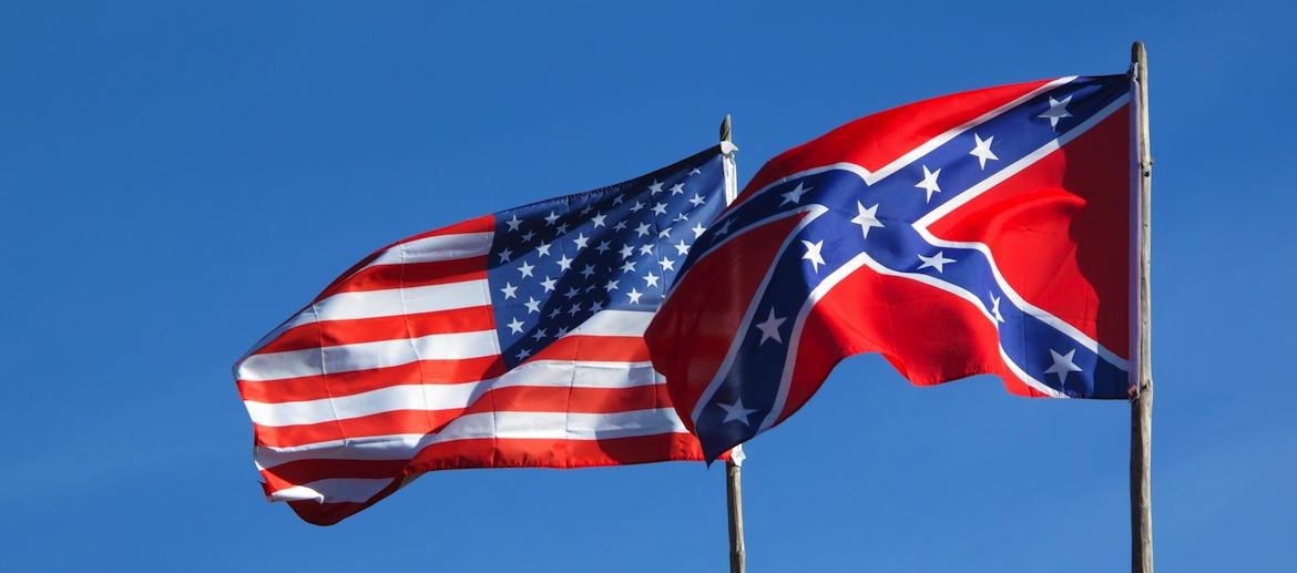 the american flag and the confederate flag flying at equal height. the confederate flag partially overlaps the american.