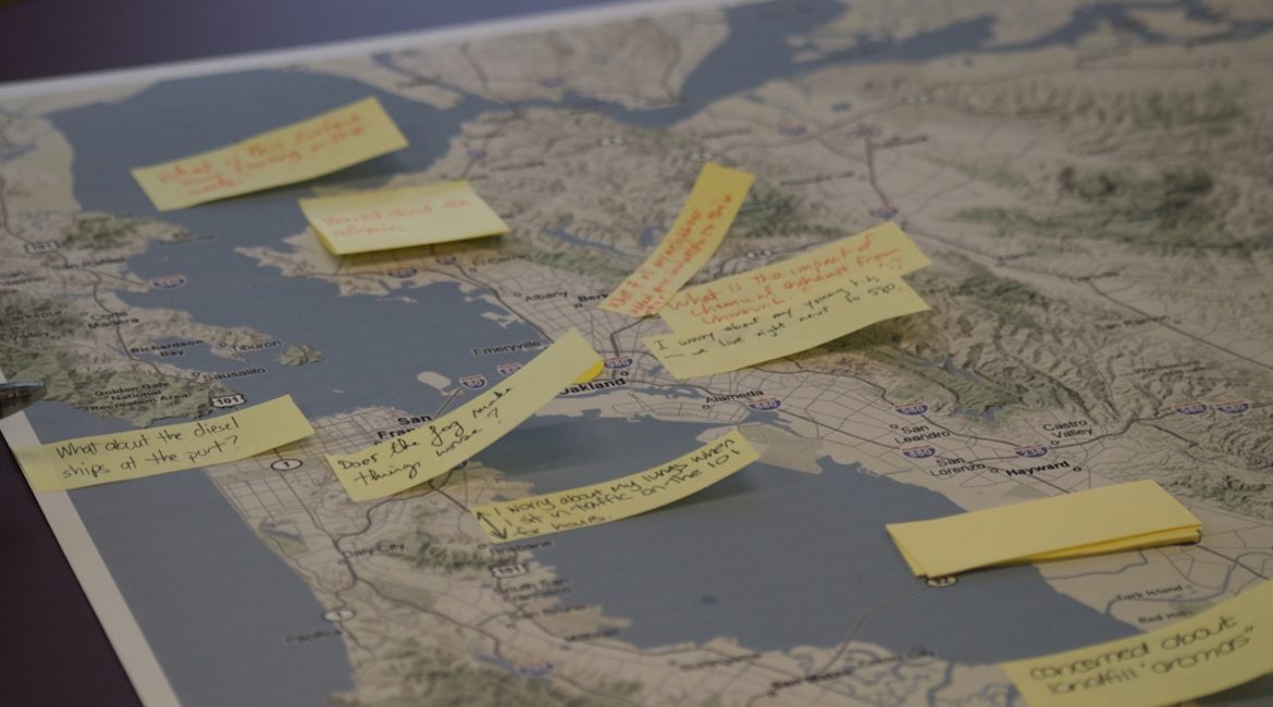 A close-up of a topographical map with a number of yellow sticky notes attached to it. The notes have different people's handwriting on them.