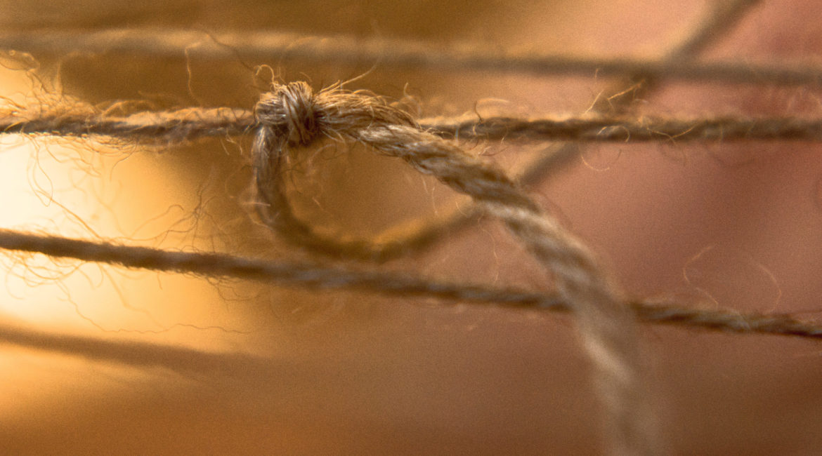 A knot tied in a piece of brown twine.