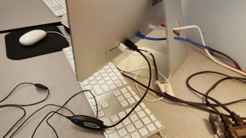 This photo is of the headset plugged into the back of the computer via its USB plug. There are a few other chords coming in and out of the computer as well.