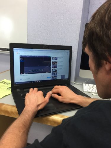 A young man typing on a laptop