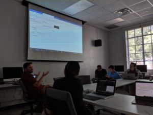 Instructor facilitating a workshop at the front of a classroom.